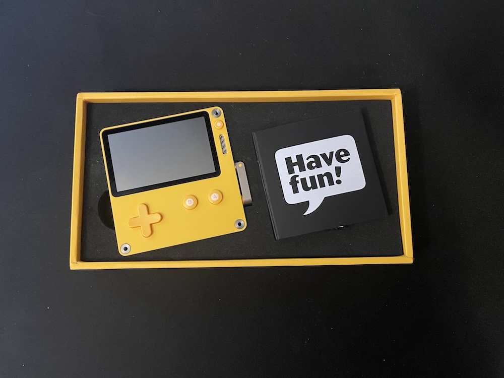 The Playdate is packaged in a small yellow box.