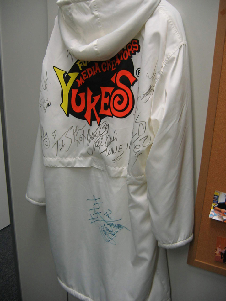 A Yuke's-themed robe signed by WWE Superstars like Trish Stratus, Ric Flair, and others.