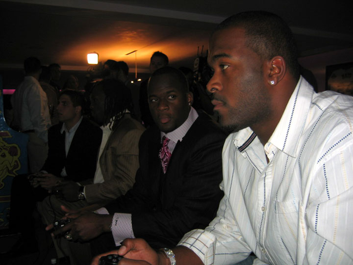 Former Texas quarterback Vince Young seems distracted as future number one overall draft pick Mario Williams checks out NCAA Football 07.