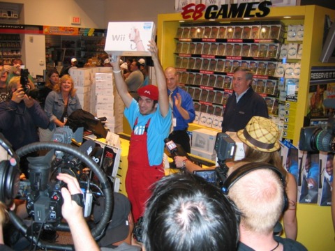 Jonathan Mann, prize in hand; Nintendo exec George Harrison is standing at the register, at right.
