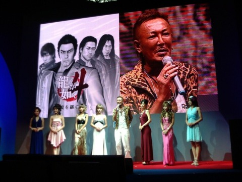  Nagoshi onstage with some of the hostesses who will be featured in the game.