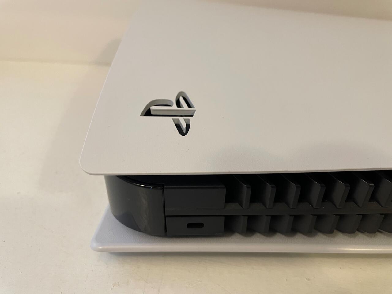 Lift and slide the corner with the PlayStation logo to remove the top plate.