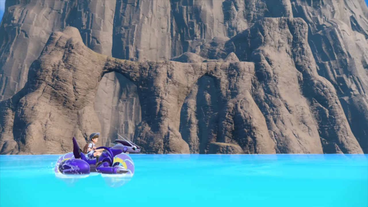 A Pokemon trainer rides Miraidon past an ocean cove.